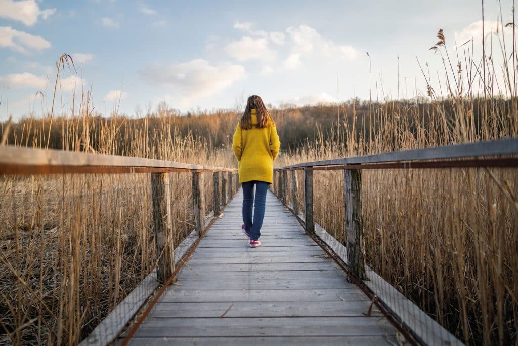 An image of a woman taking a walk in the countryside.