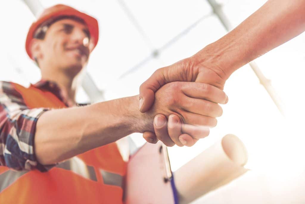 An close up image of a construction worker giving a handshake.