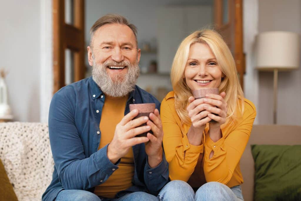 An image of an older couple drinking cups of coffee.