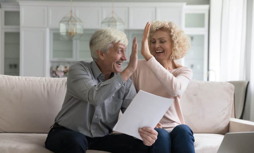 An image of an older couple high-fiving each other.