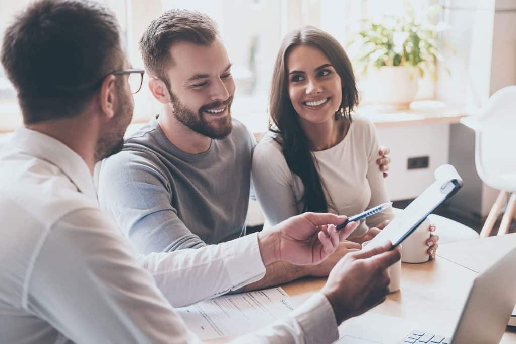 An image of a couple looking through paperwork with an advisor.