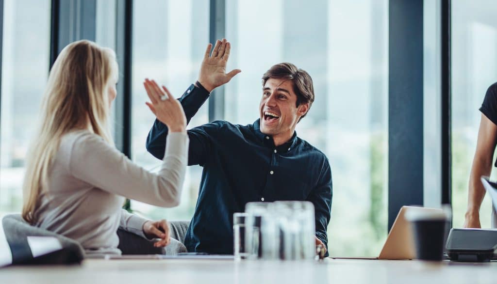 An image of a young couple high-fiving each other.