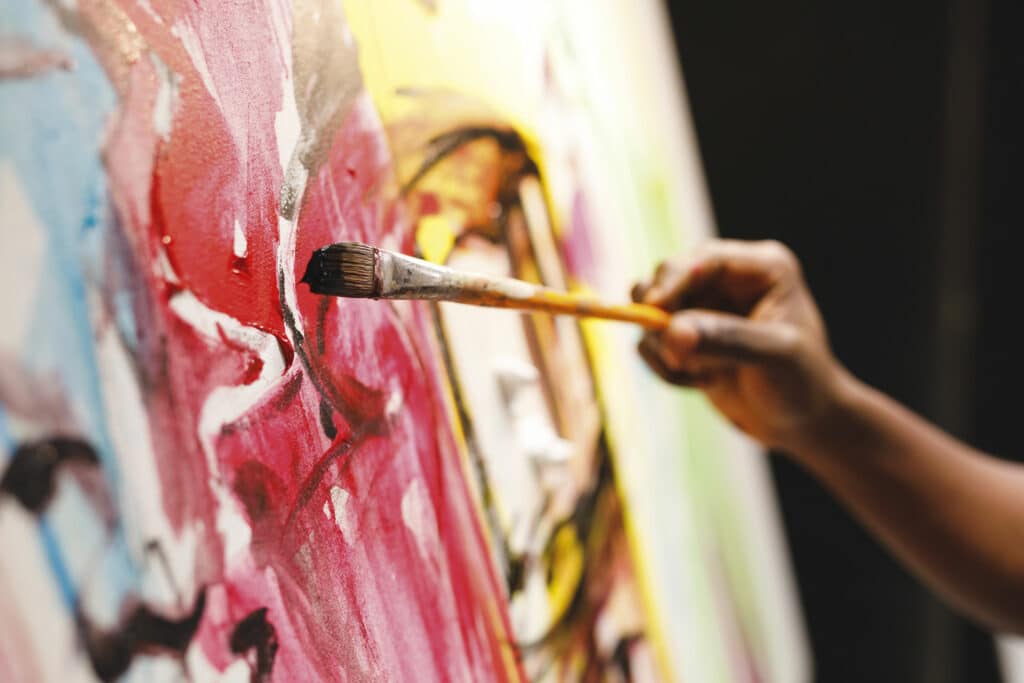 Image of somebody painting a piece of abstract art.