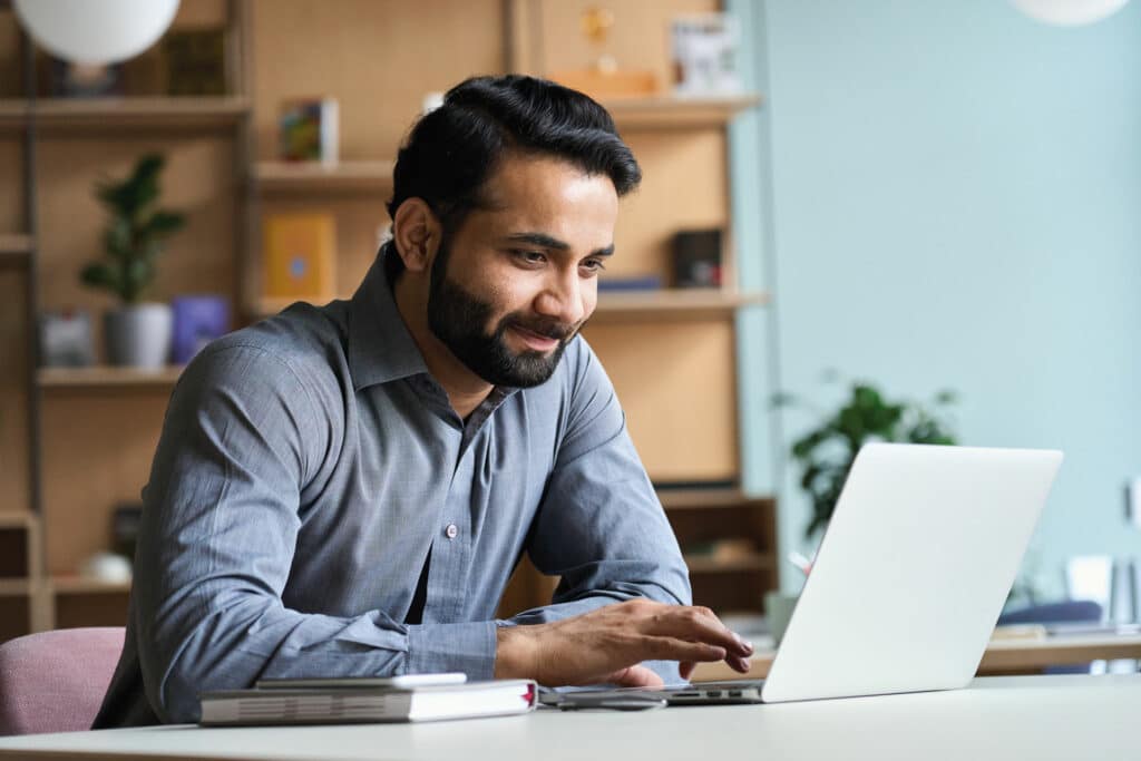 Image of a man typing on his laptop.